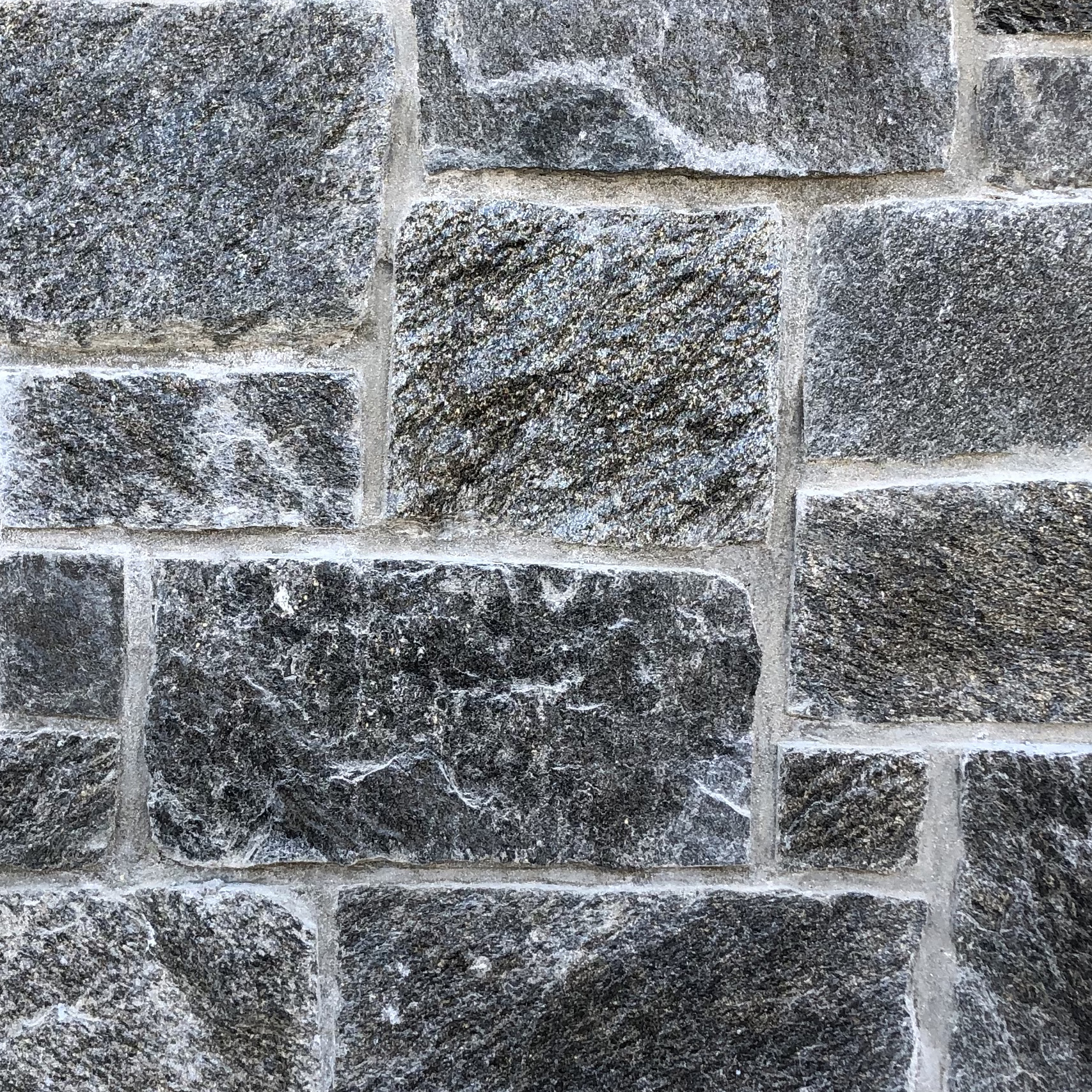 Natural Facing Ramone Brown Mosaic Sawn Thin Stone installed on a wall near a park bench