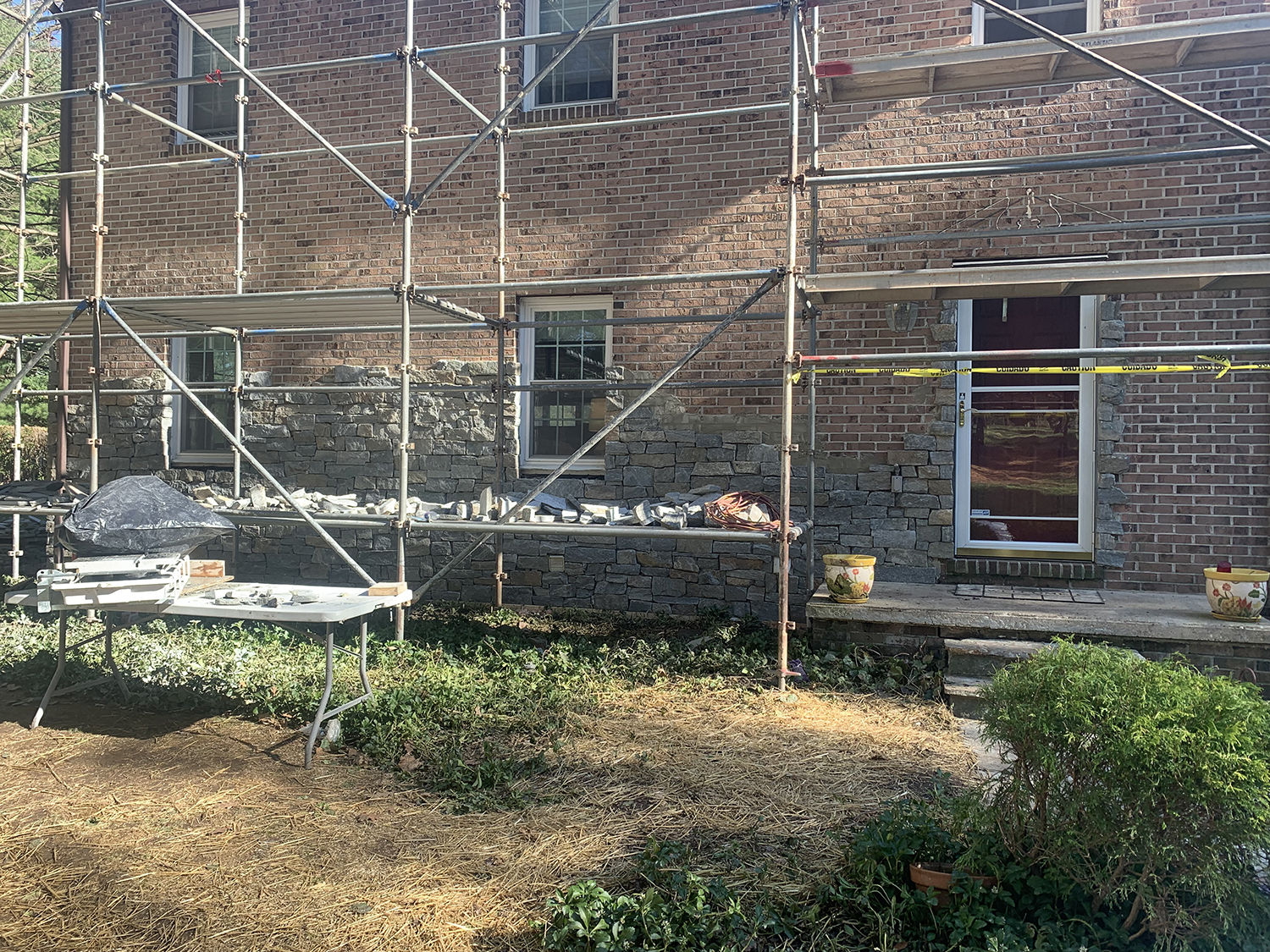 A job site where stone is getting installed over brick